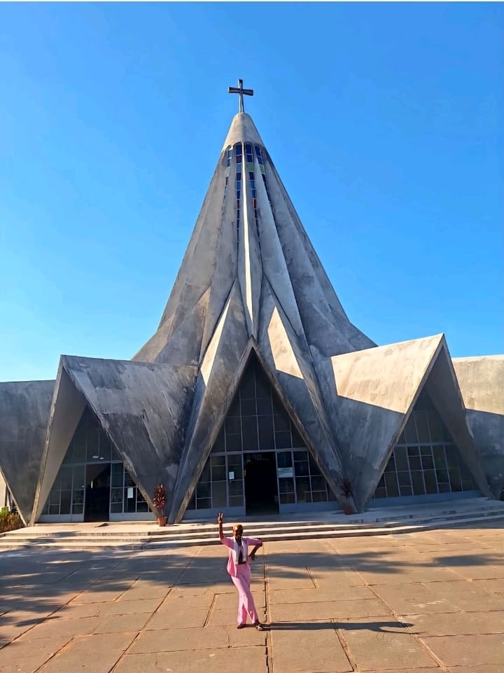 Eunice in a pink suit in front of the Church of Saint Anthony in Maputo, known as the lemon squeezer