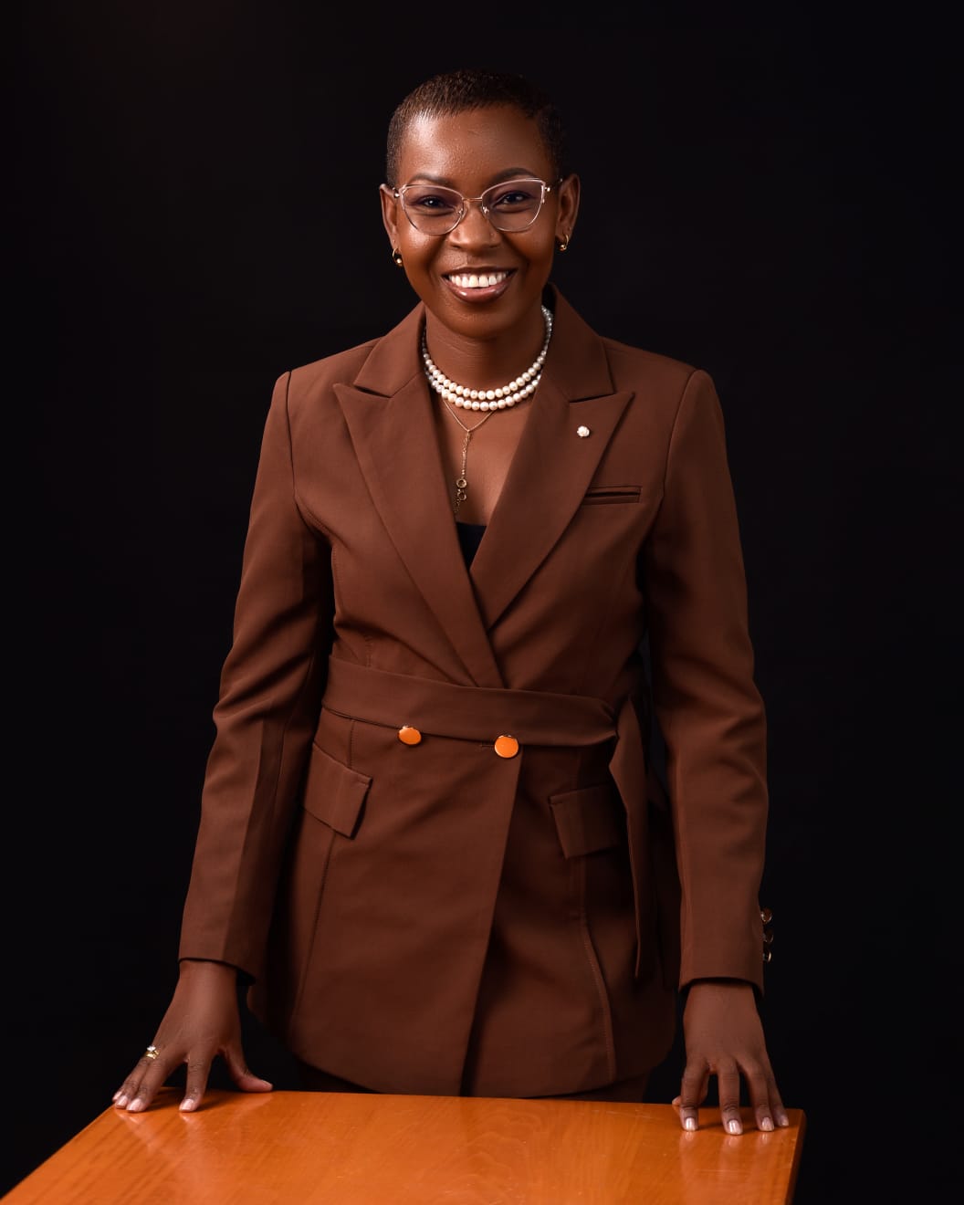Eunice Ireri — Emerald suit — seated crossed legs