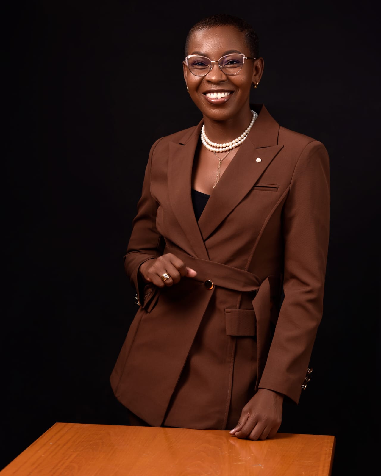 Eunice Ireri — Navy suit — smiling seated